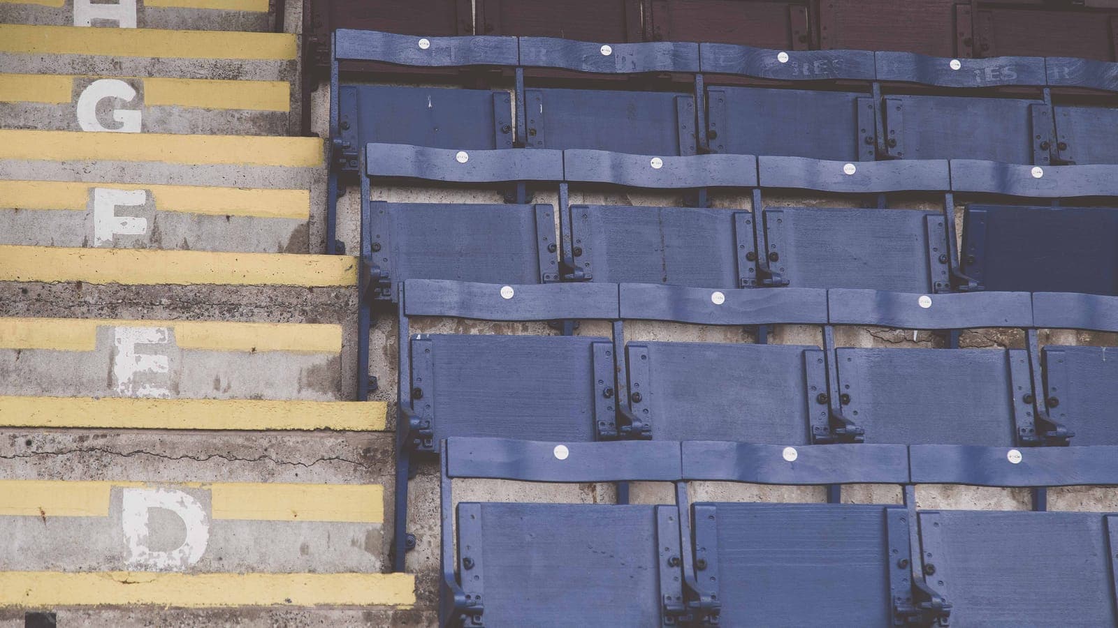 Rangées de sièges vides et escalier peint en jaune dans une tribune